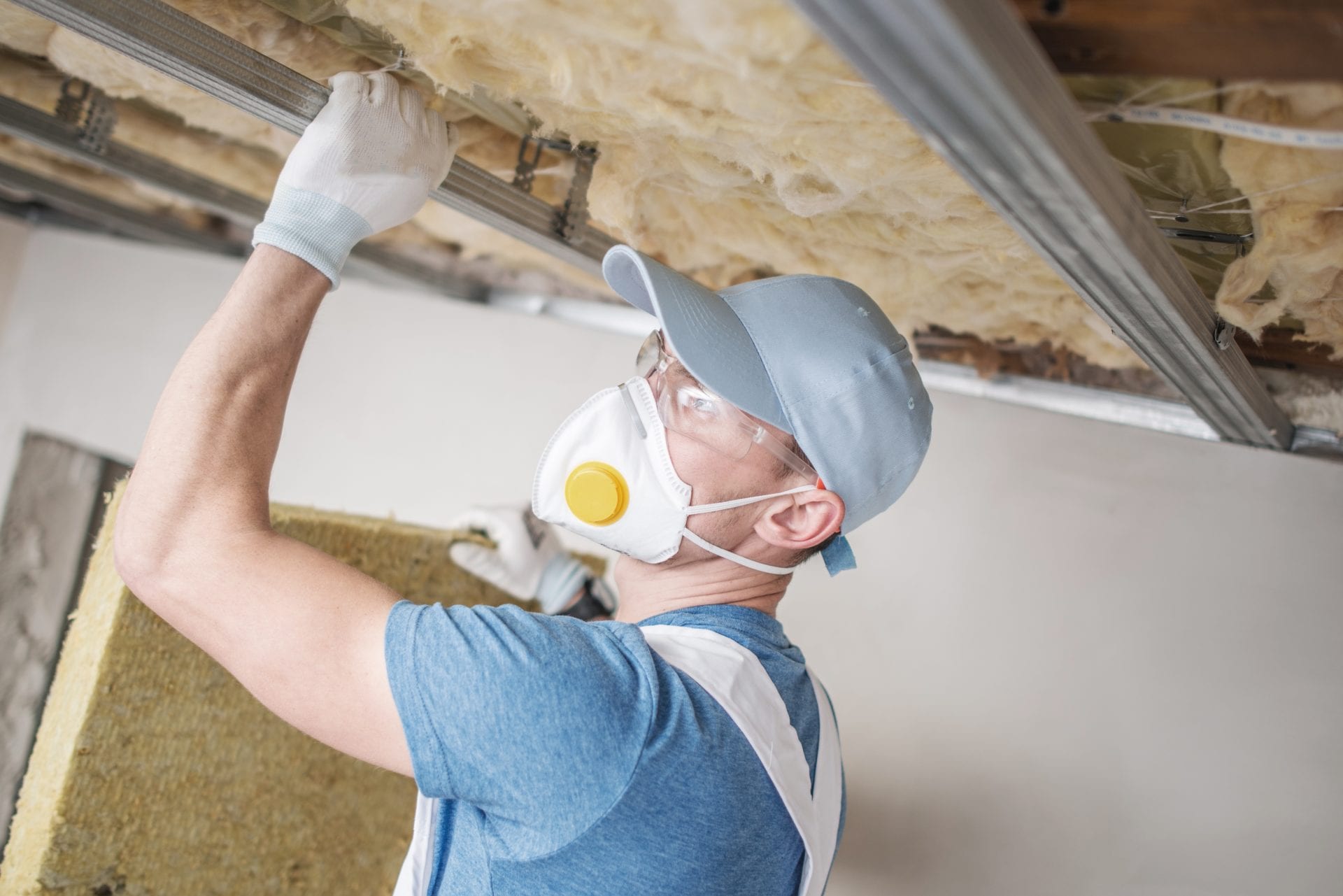 Wool Home Insulating. Caucasian Home Renovation Worker with Mineral Wool.